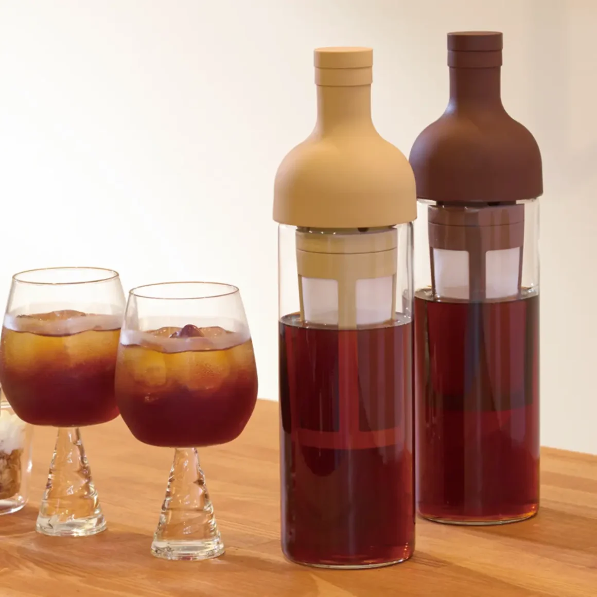 a group of glasses and hario coffee cold brew bottles with coffee in them