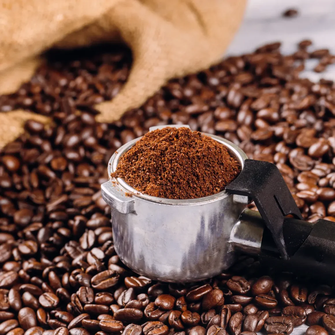 a roasted coffee beans and ground coffee in a portafilter