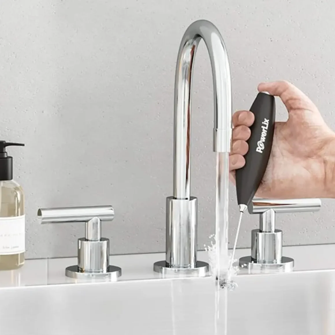 a hand holding a powerlix frother pro under running water
