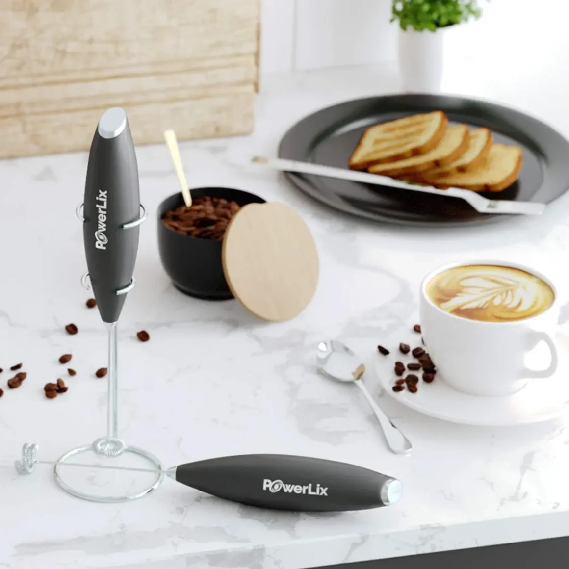 a powerlix milk frother pro and coffee cup with spoons and food on a plate