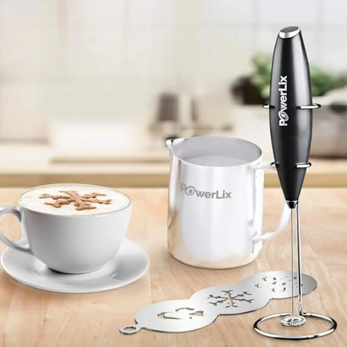 a coffee cup and milk frother set on a table
