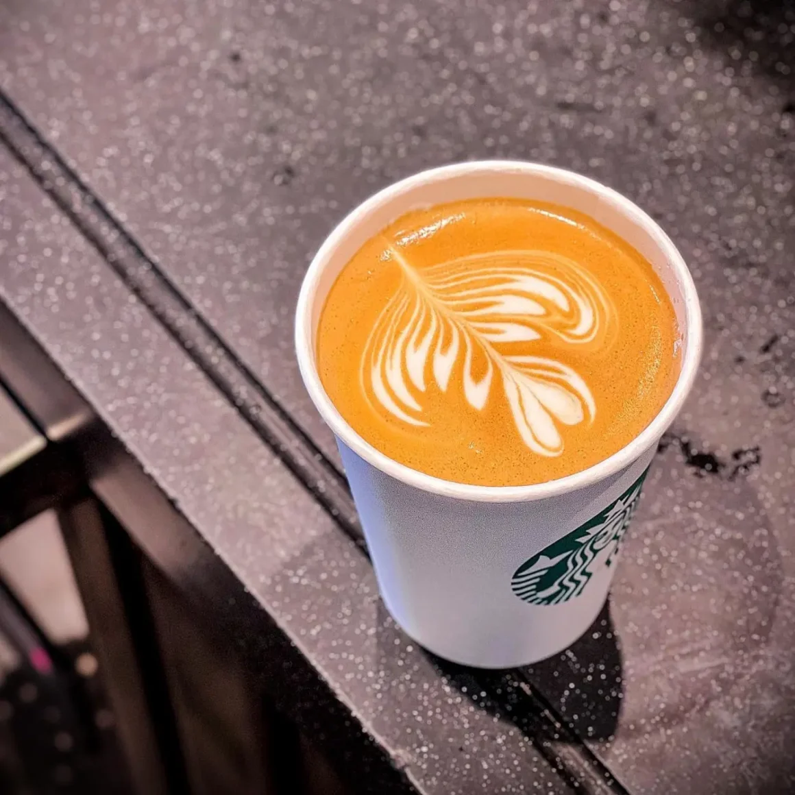 a cup of coffee with a leaf design on top