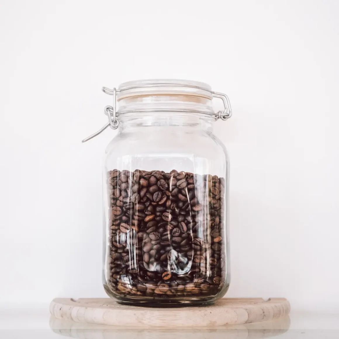 a glass jar filled with roasted coffee beans