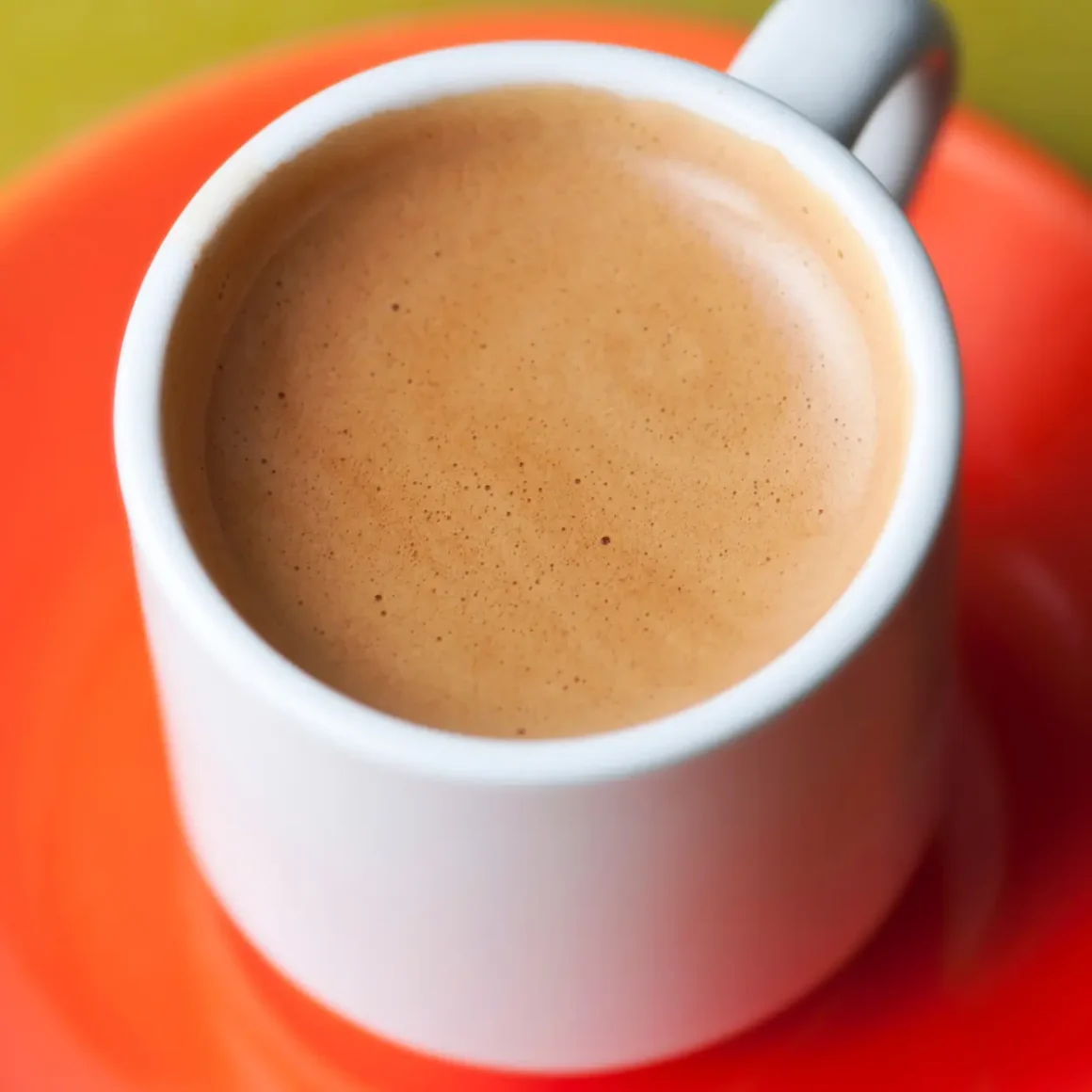 a cup of blonde espresso on a plate