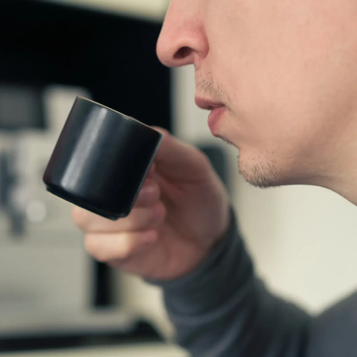 a person holding a black cup