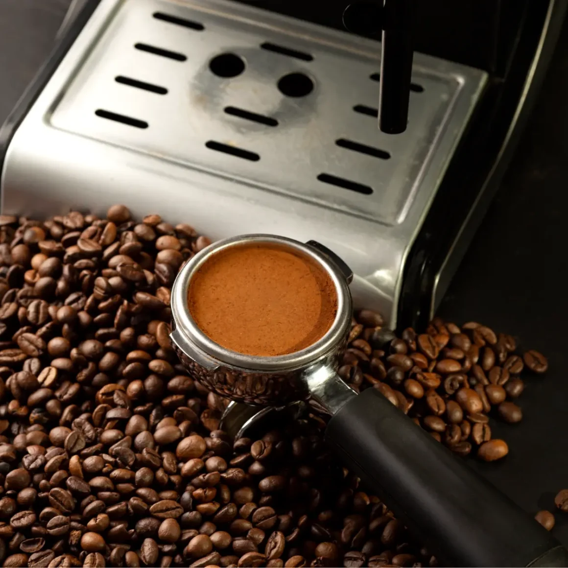 an espresso machine with a portafilter on a pile of coffee beans