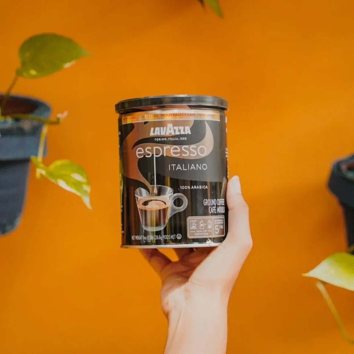 a hand holding a can of lavazza espresso italiano