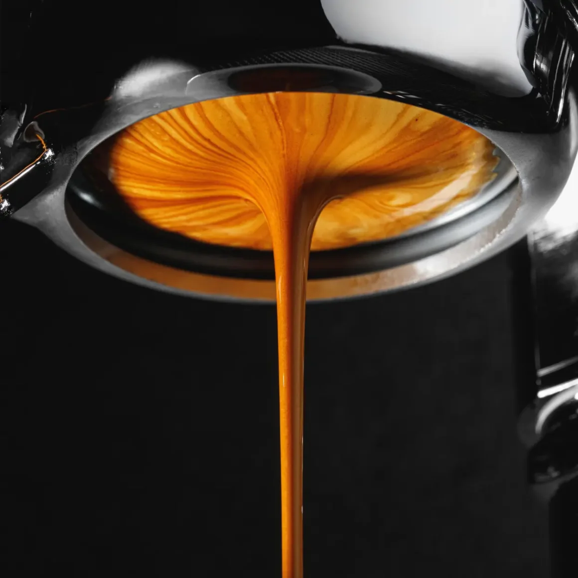 a close up of a bottomless portafilter in an espresso machine