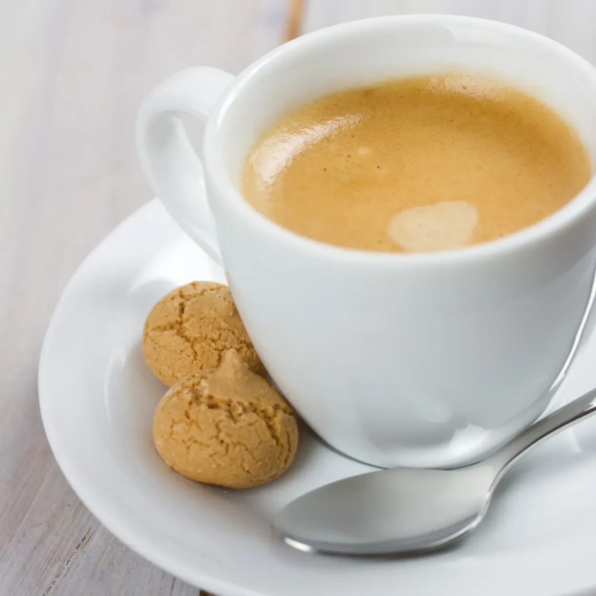 a cup of blonde espresso and cookies on a saucer
