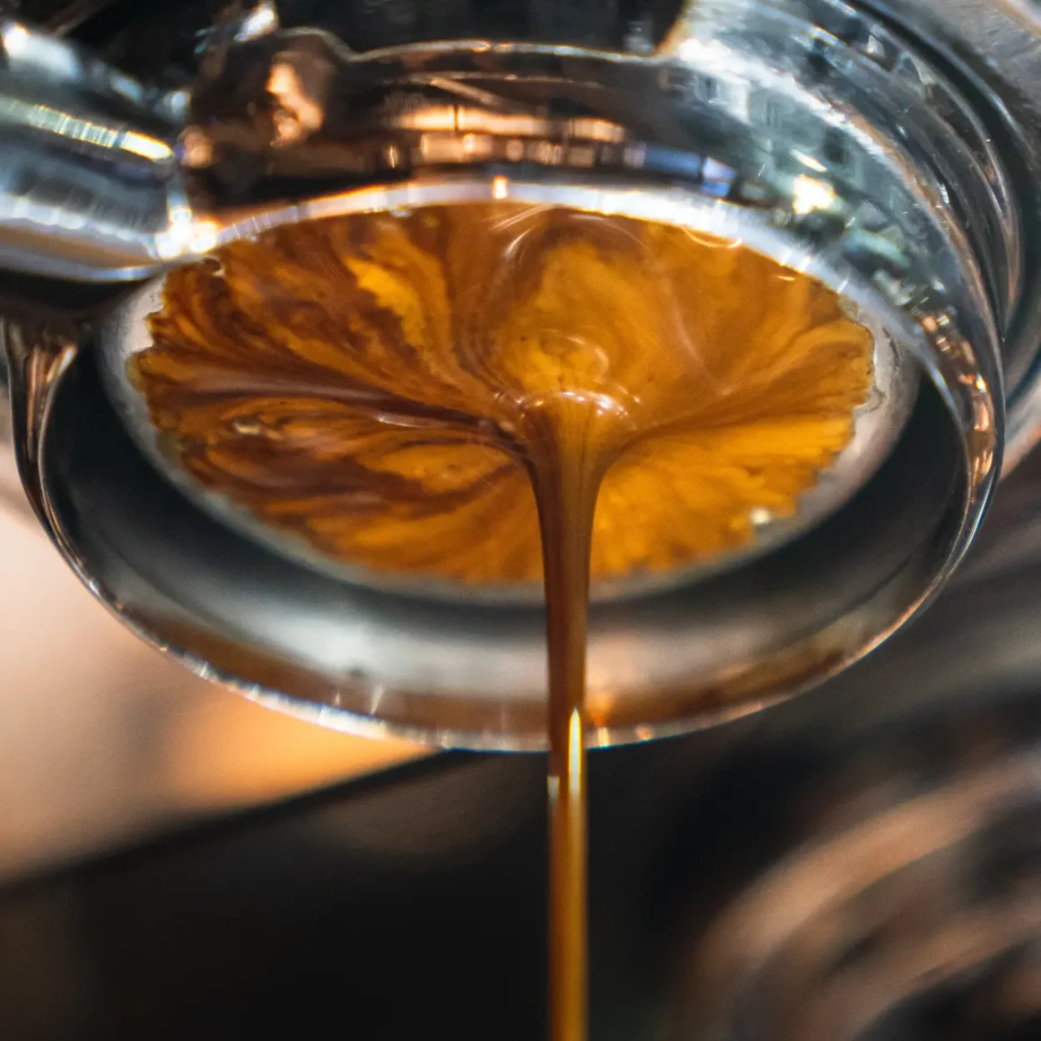 a close up of a bottomless portafilter in an espresso machine