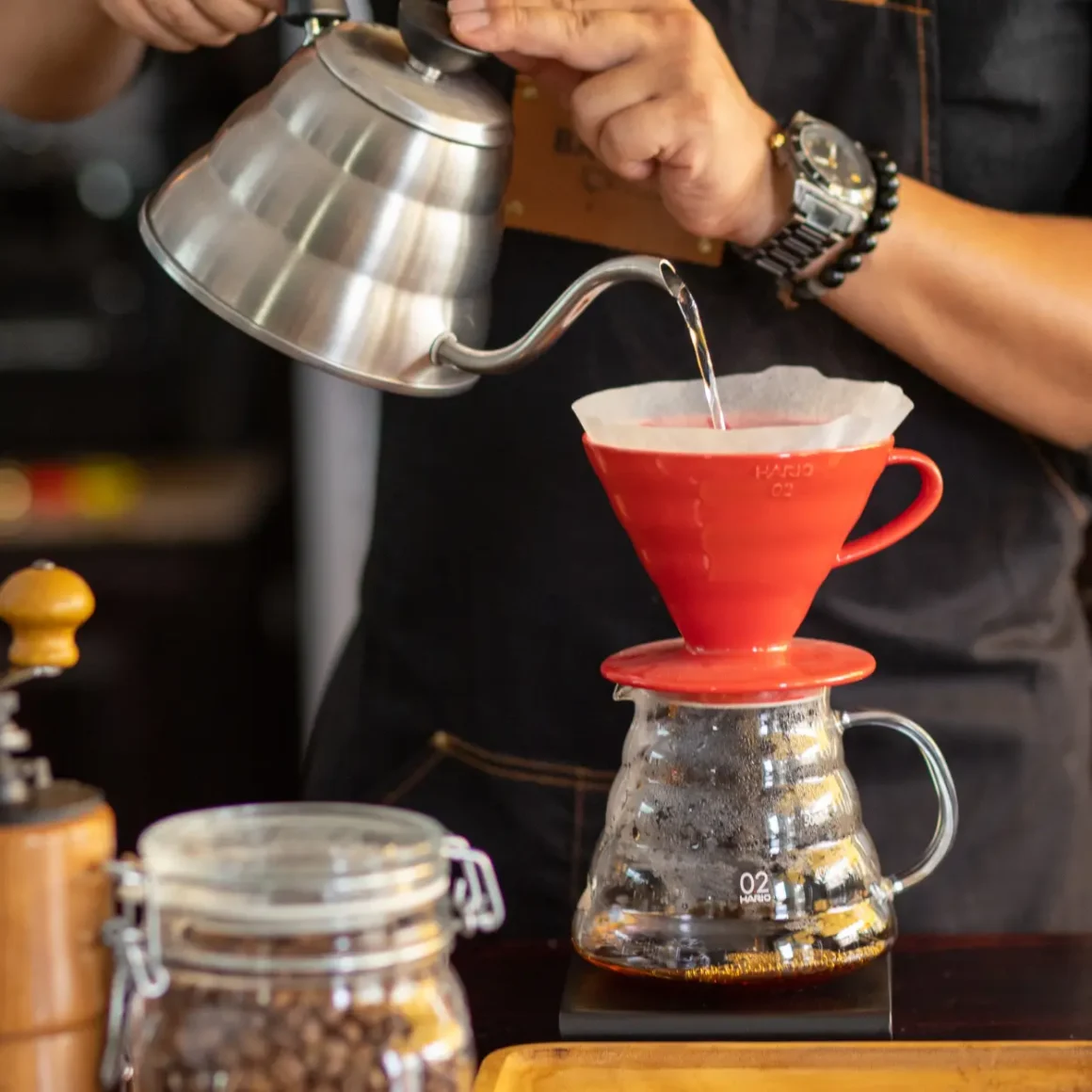 barista pouring coffee into a pour-over coffee maker