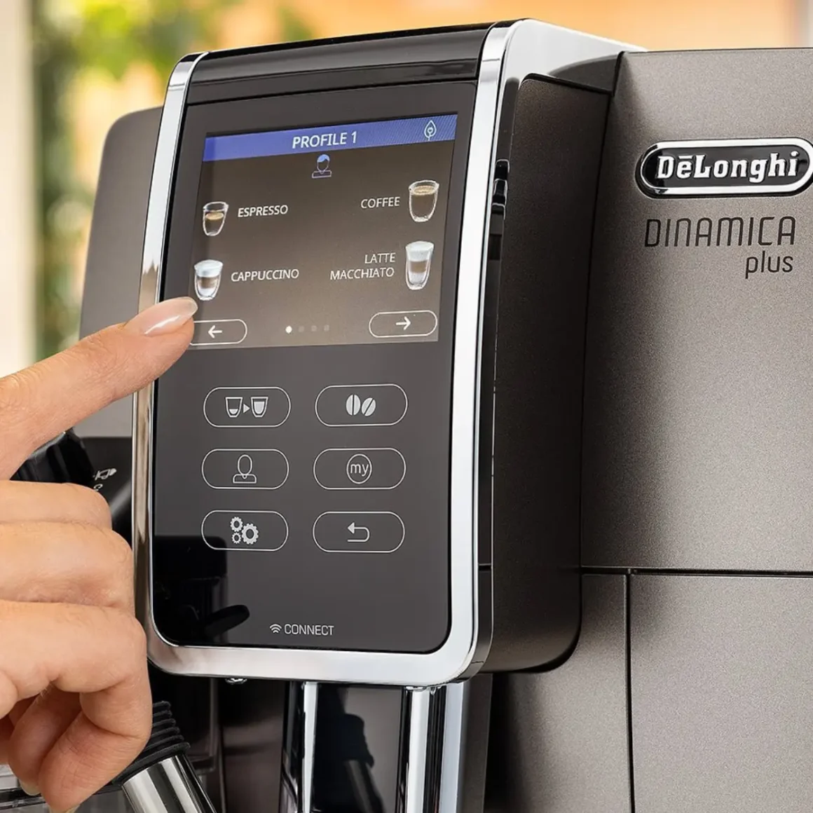 a person's finger pointing at a screen of a delonghi dinamica plus coffee maker