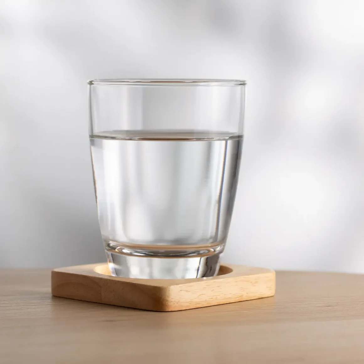 a glass of water on a coaster