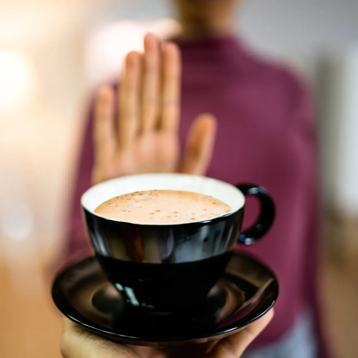 a hand holding a cup of coffee