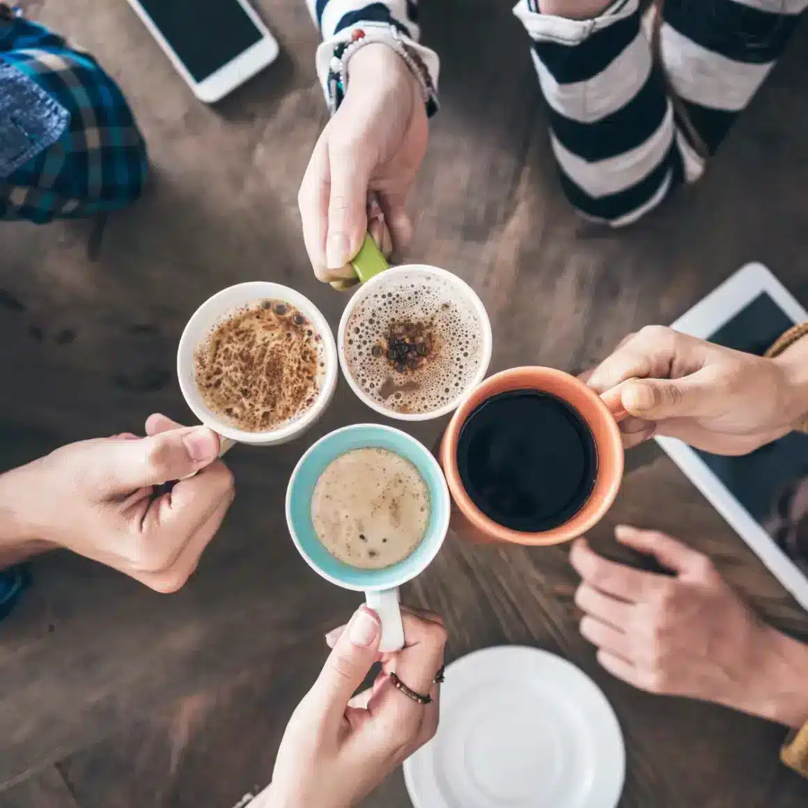 a group of people holding cups of coffee drinks
