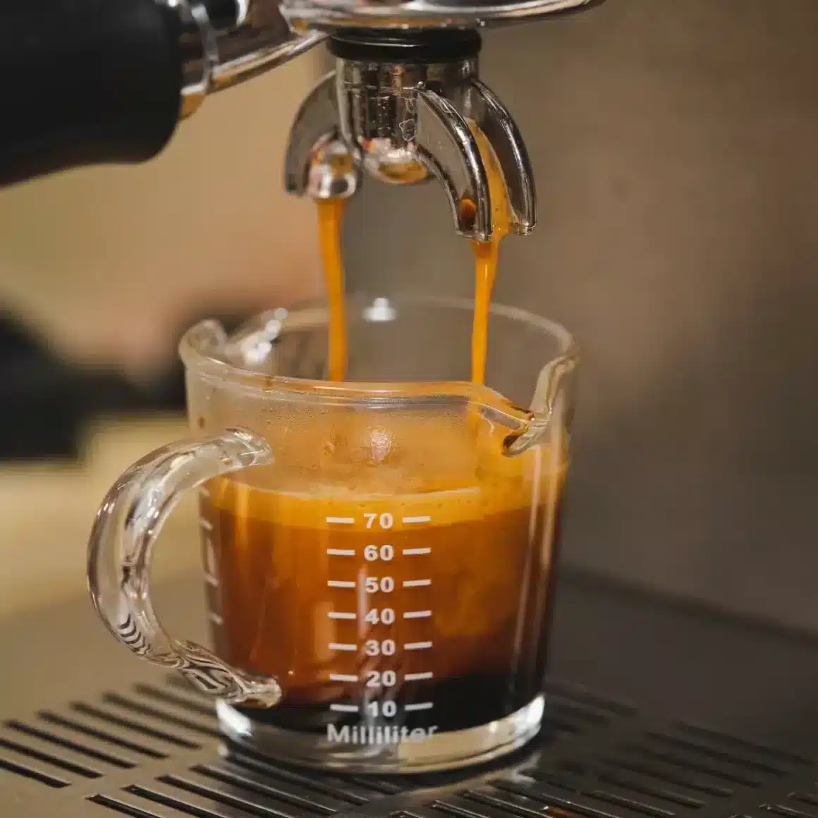 an espresso machine pouring coffee into a glass cup