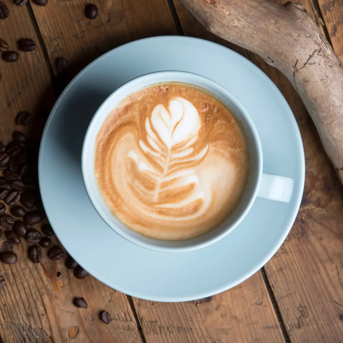 a cup of latte with a leaf design on top