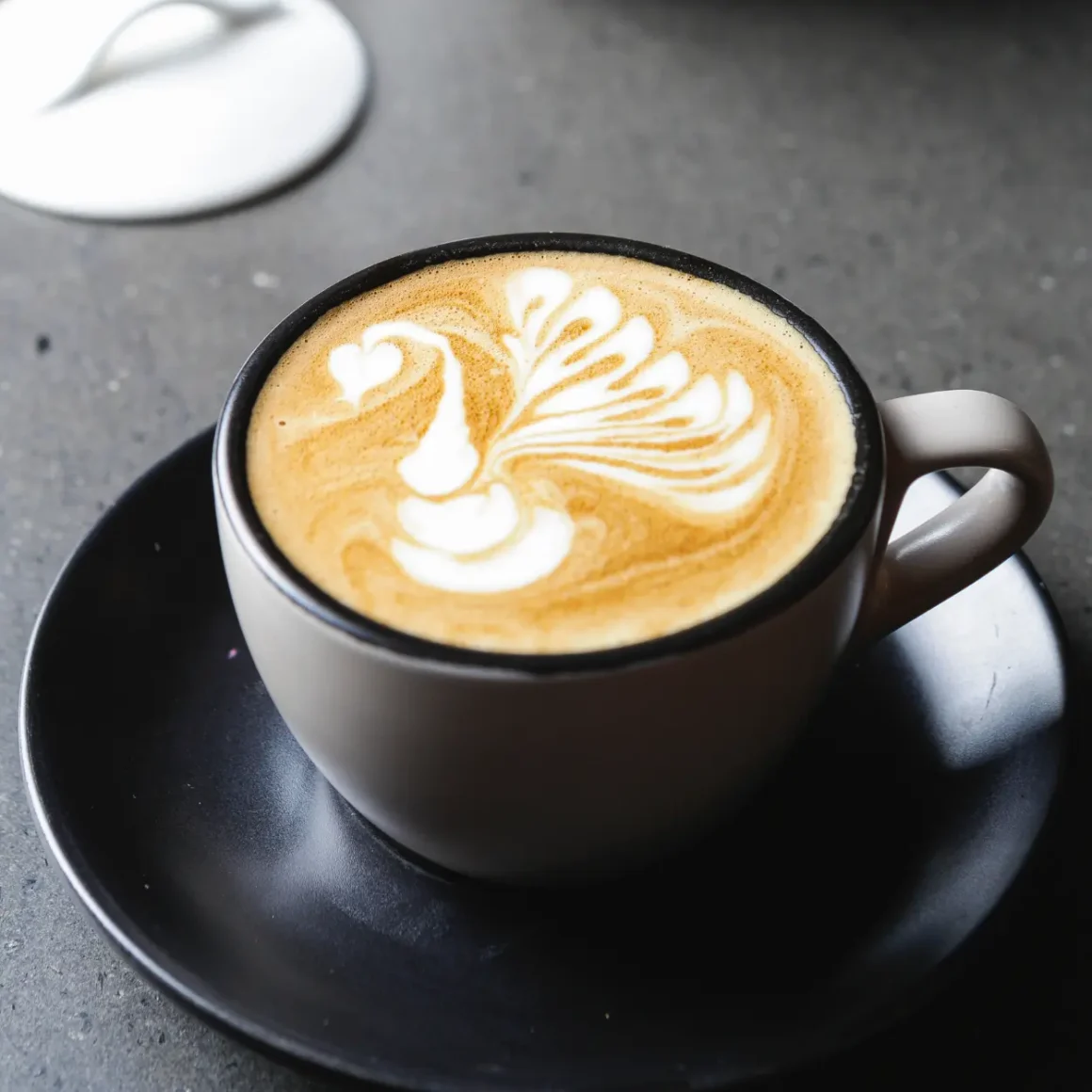 a cup of latte with a design in the foam