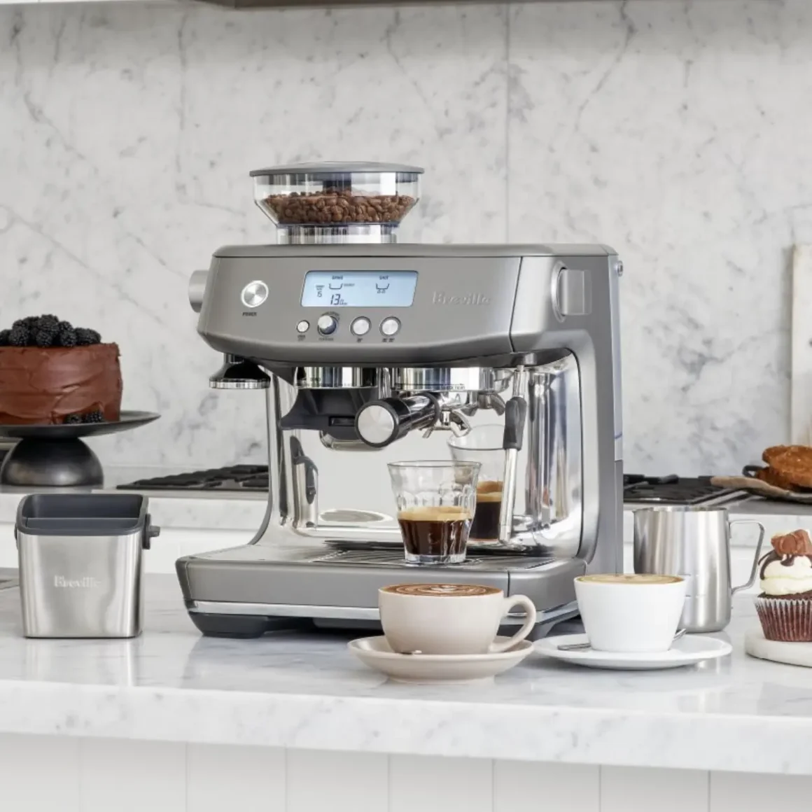 a breville barista pro espresso machine and cupcakes on a counter