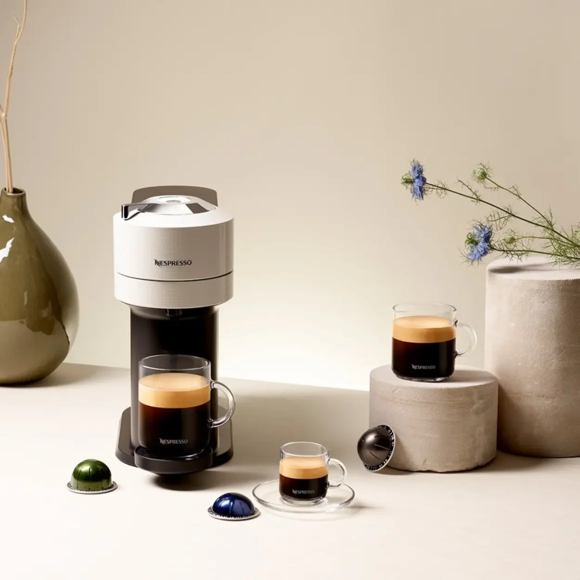 a nespresso machine and cups of coffee on a table