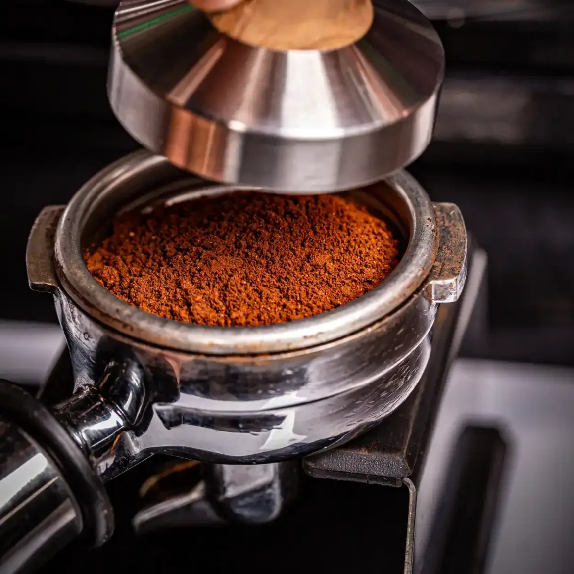a close up of a portafilter with ground coffee in it