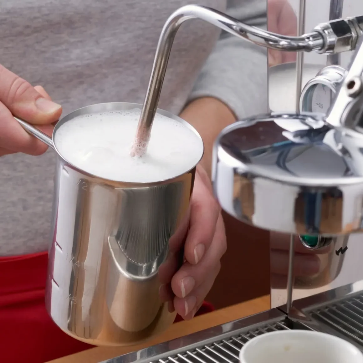 barista pouring milk into a cup