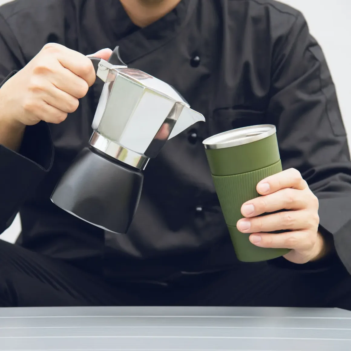 a person pouring coffee into a cup from a moka pot