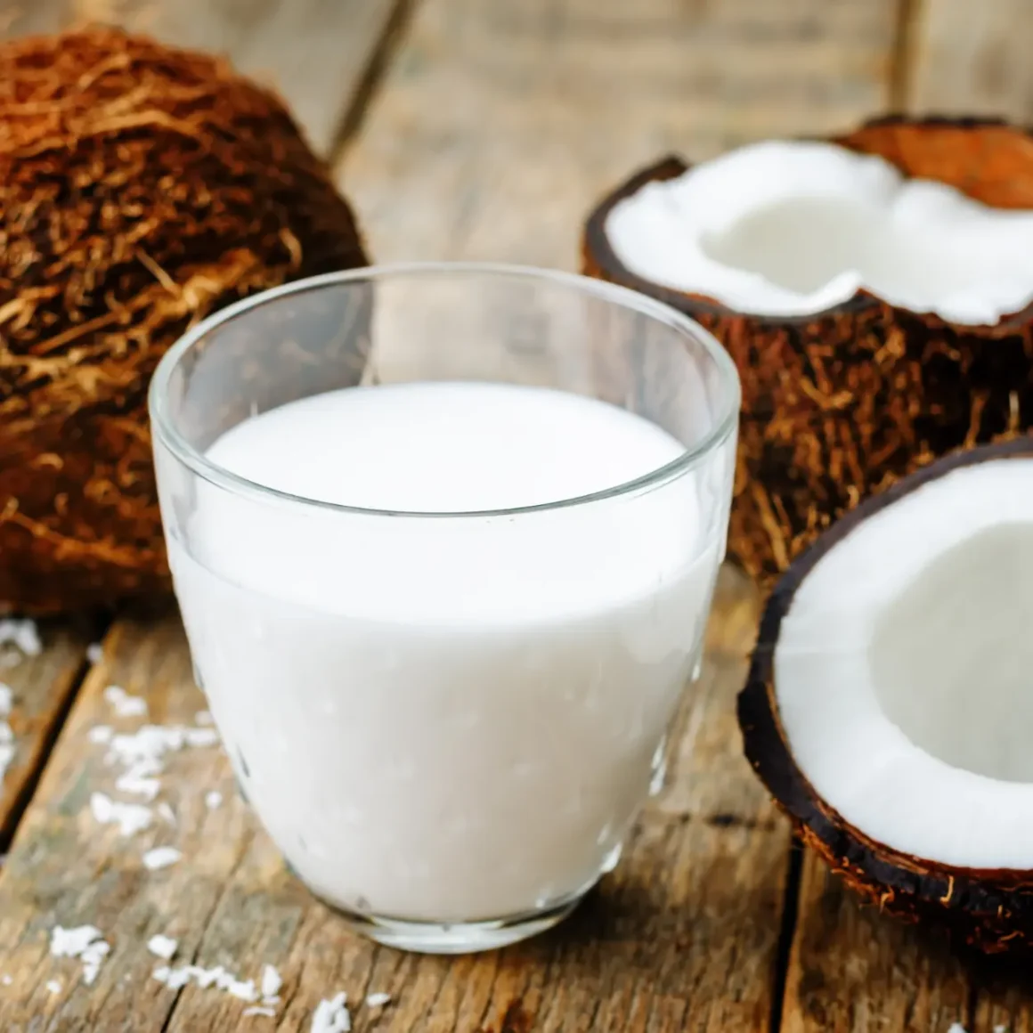 a coconuts and a glass of coconut milk