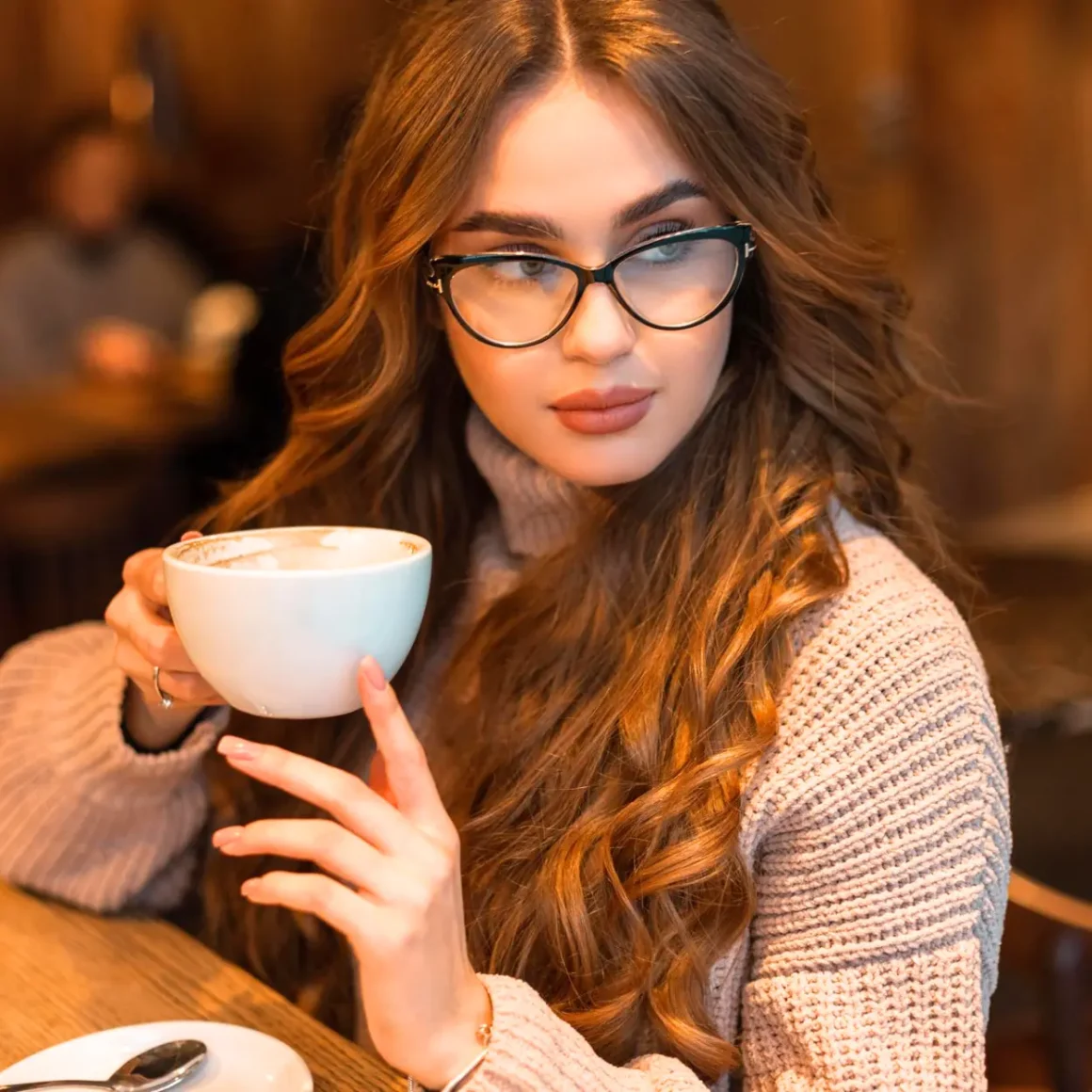 a woman holding a cup of coffee