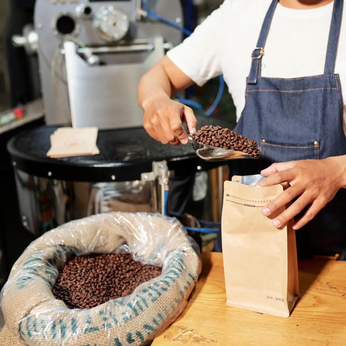 a person pouring coffee beans into a bag