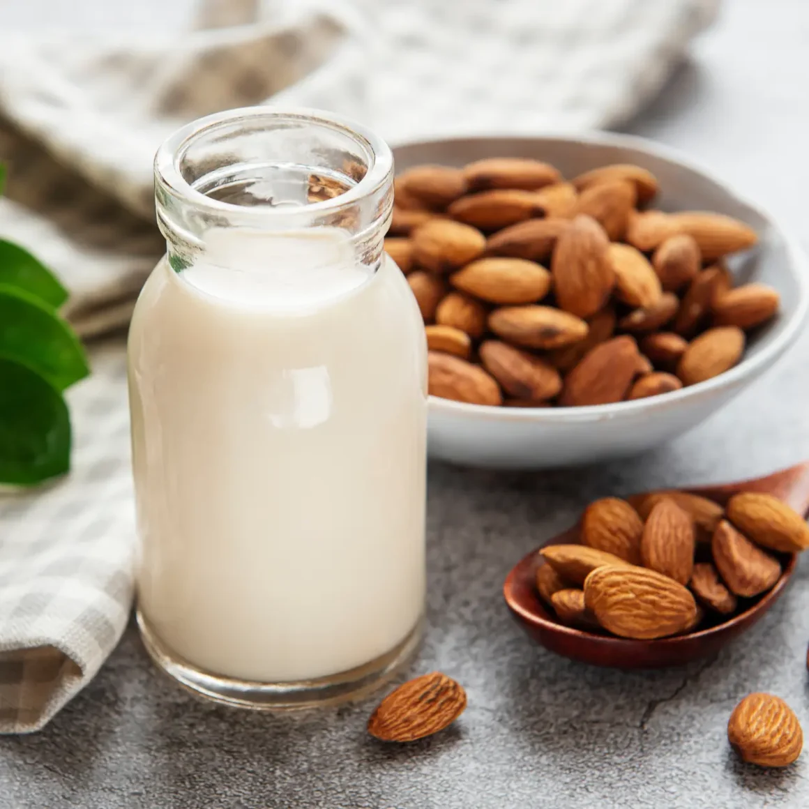 a bowl of almonds and a bottle of almond milk