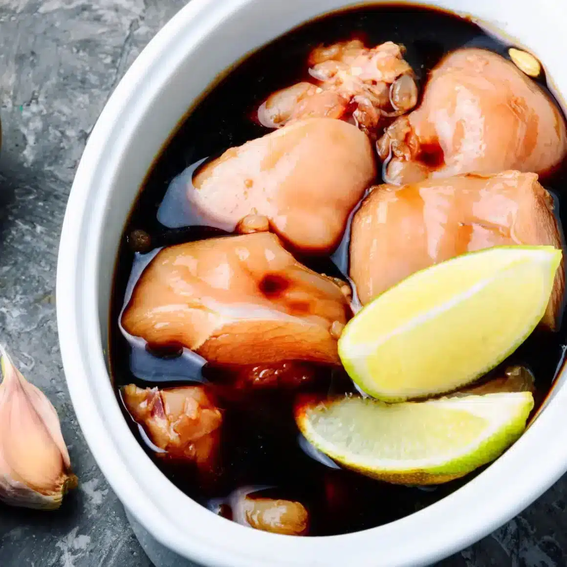 a bowl of food with a lemon wedges and garlic