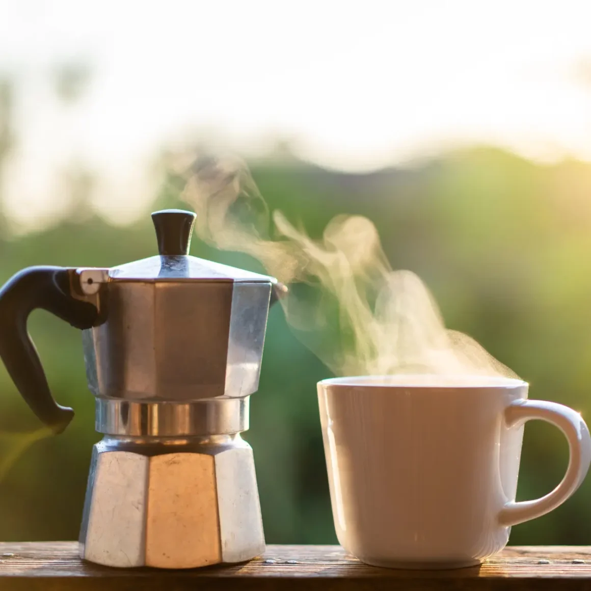 a moka pot and a cup of coffee
