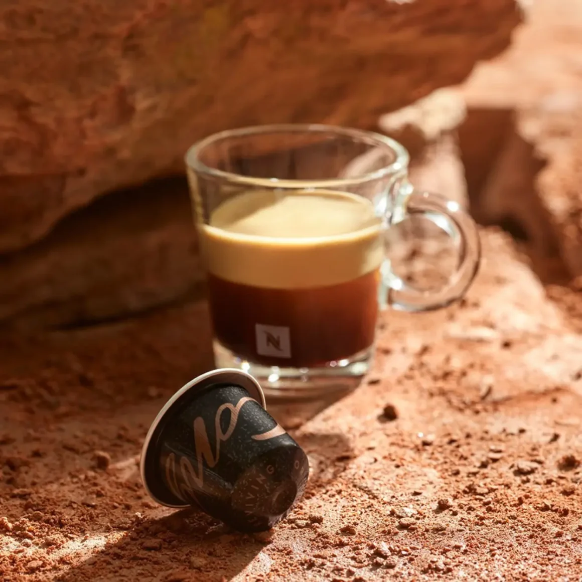 a nespresso pod and a glass of coffee