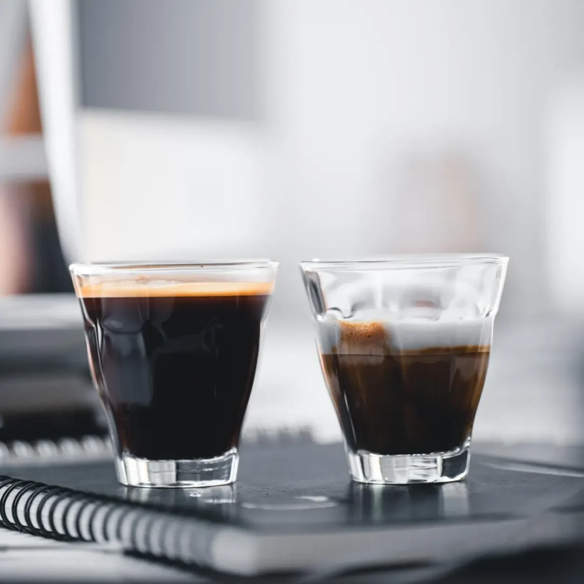 two glasses of doppio espresso and single espresso on a notebook