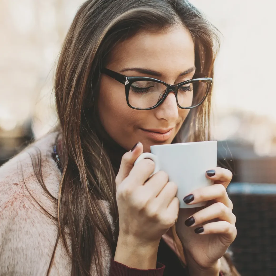 a woman holding a cup of coffee