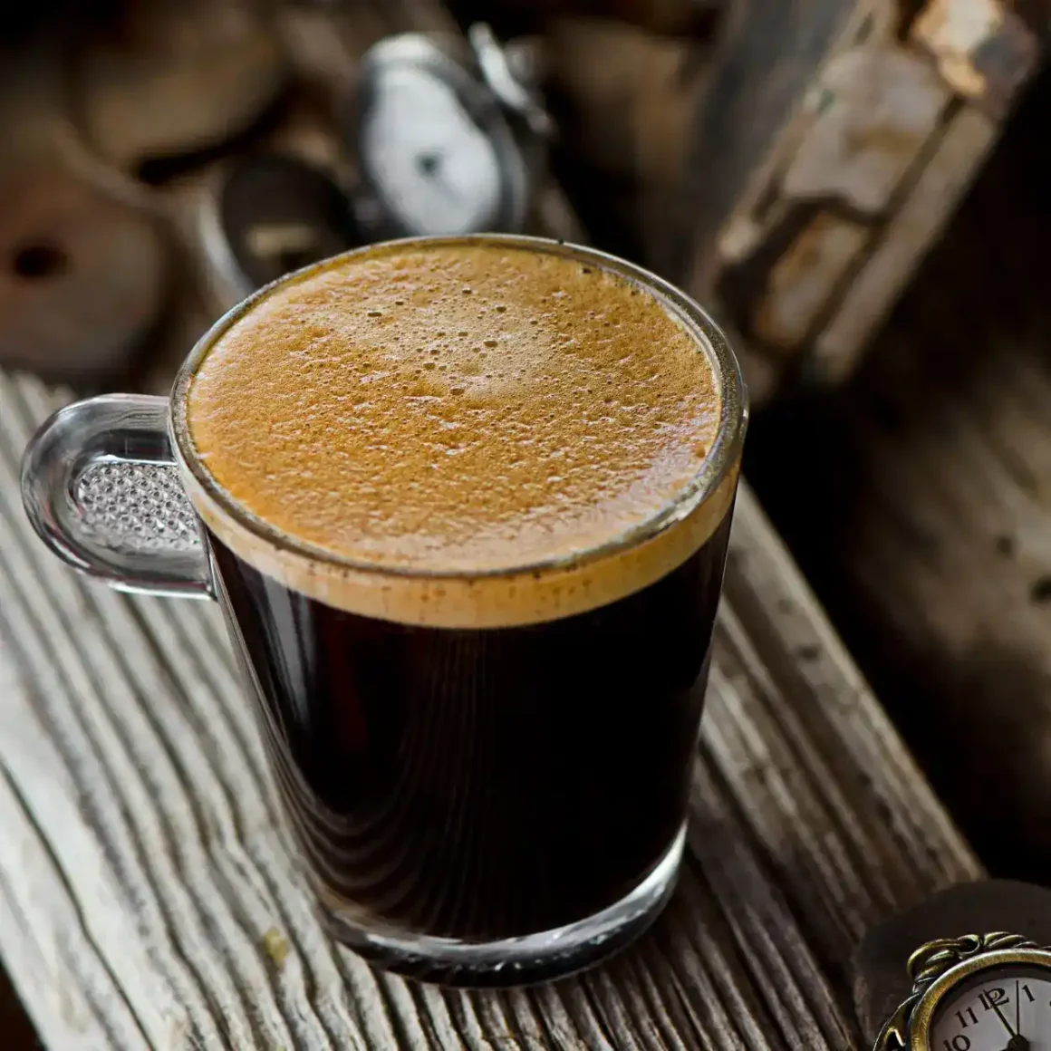 a glass of doppio espresso on a wood surface