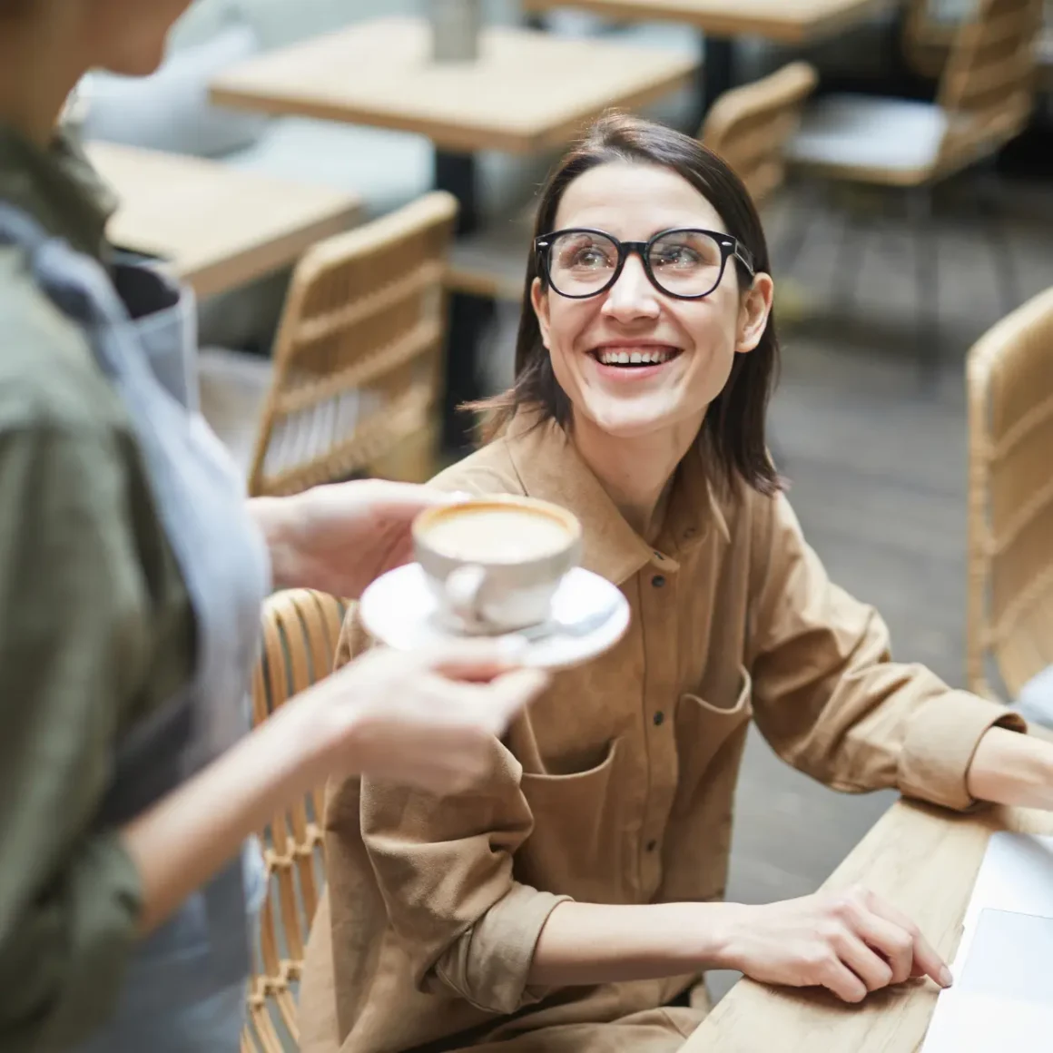 a person holding a cup of coffee and smiling