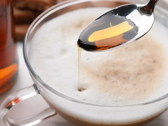 a spoon with a coffee in a cup witn vanilla extract in it