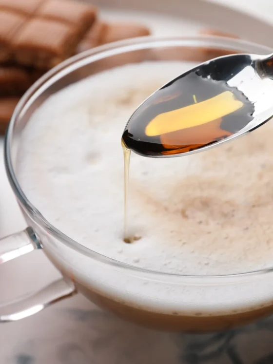 a spoon with a coffee in a cup witn vanilla extract in it