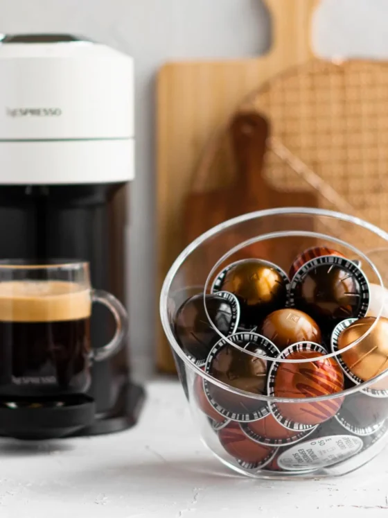 a bowl of nespresso pods and a coffee maker