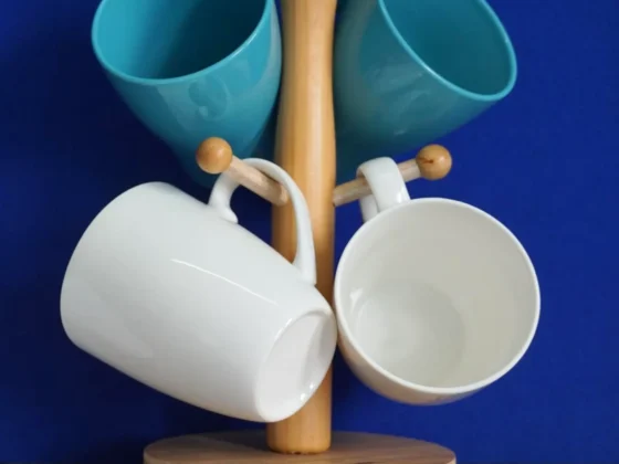 a group of porcelain and ceramic mugs on a wooden stand