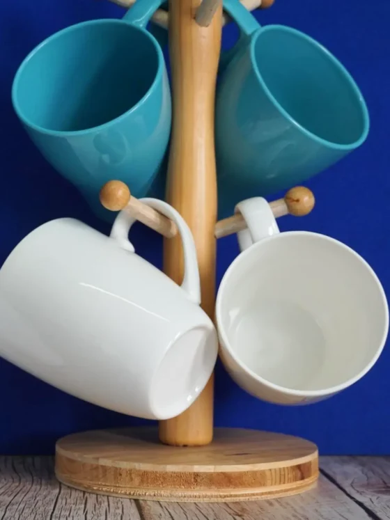 a group of porcelain and ceramic mugs on a wooden stand