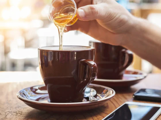 a person pouring a coffee sweetner into a cup of coffee