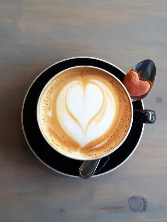a cup of coffee with a heart design in the foam