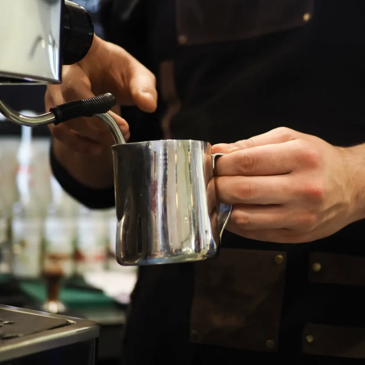 a person using a milk frother