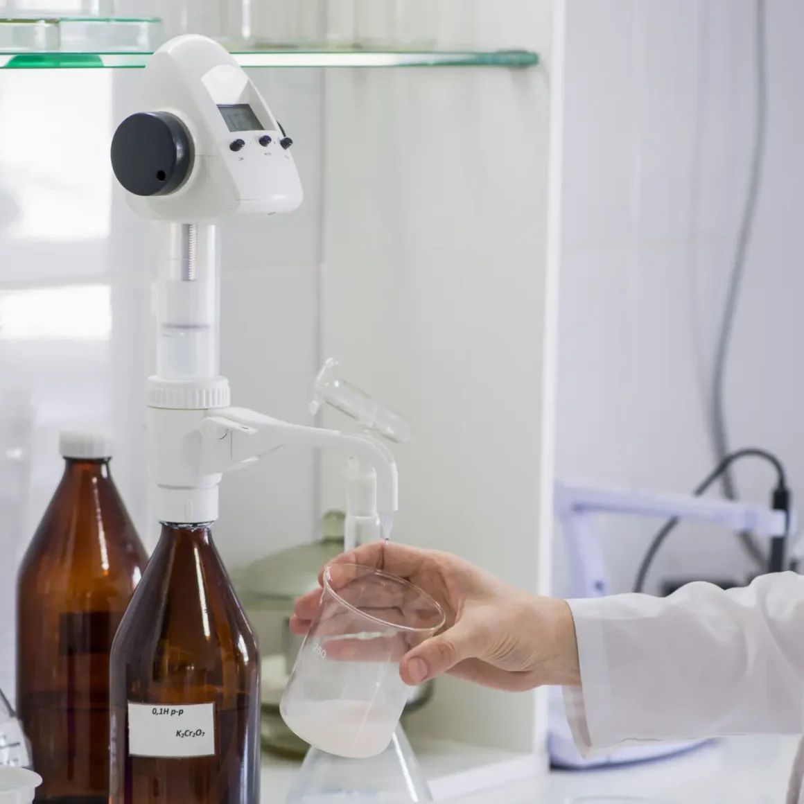 a person holding a beaker with liquid in it