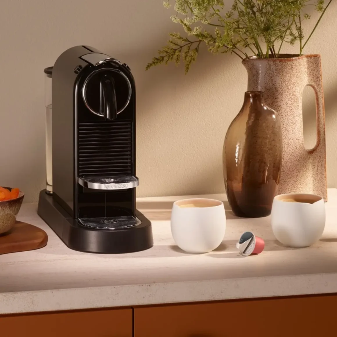 a nespresso citiz espresso machine and cups on a counter