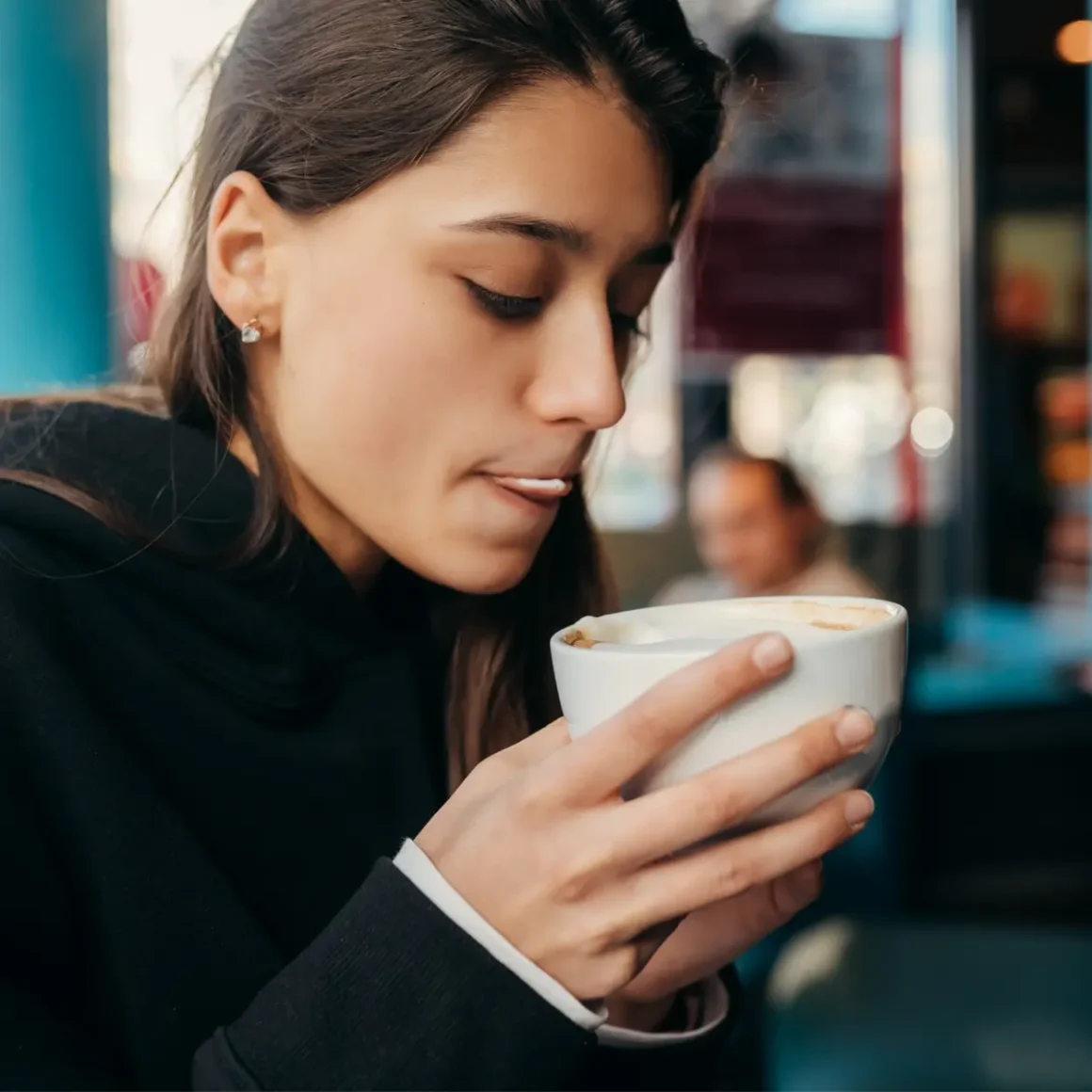 a woman holding a cup of latte