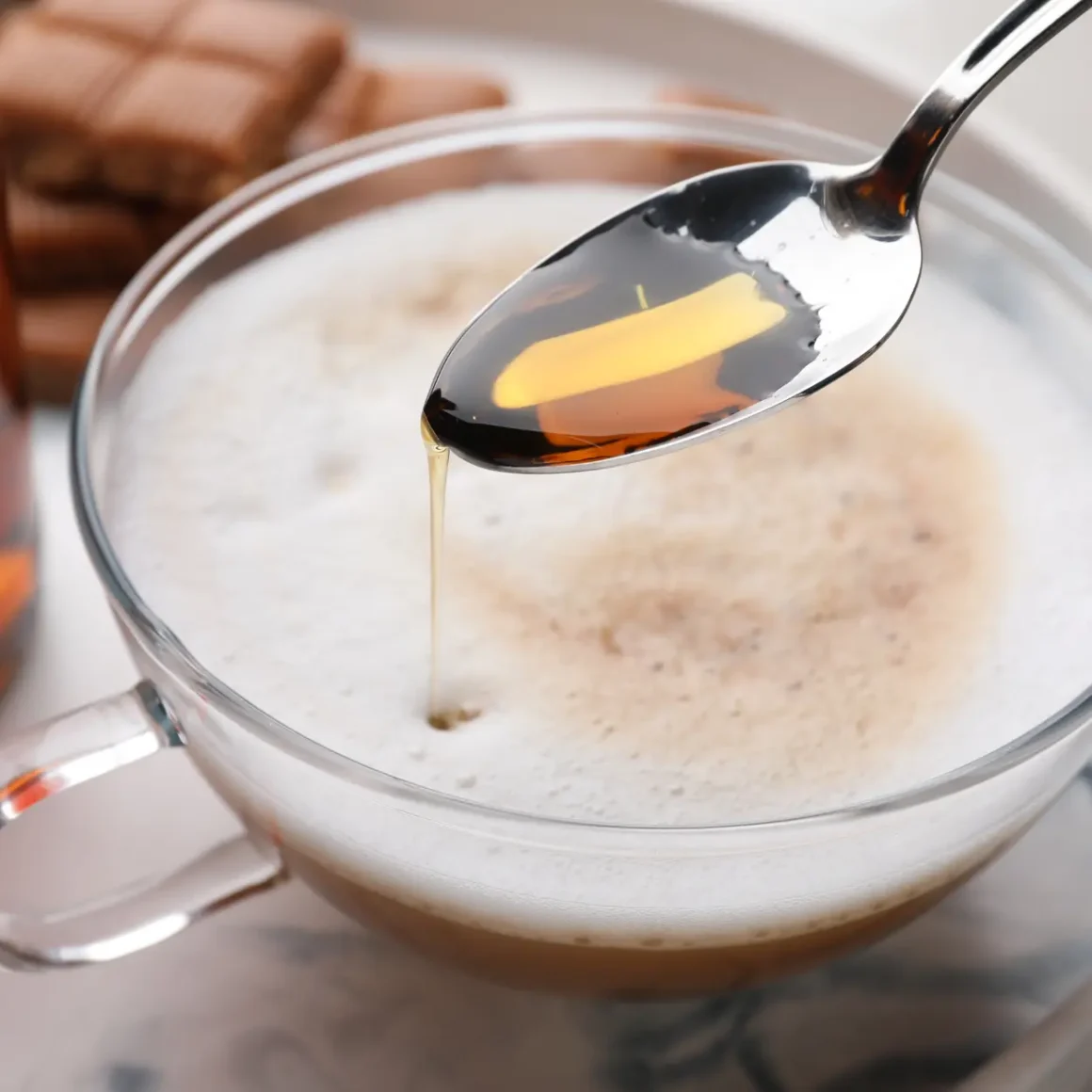 a spoon with a coffee in a cup witn vanilla extract in it